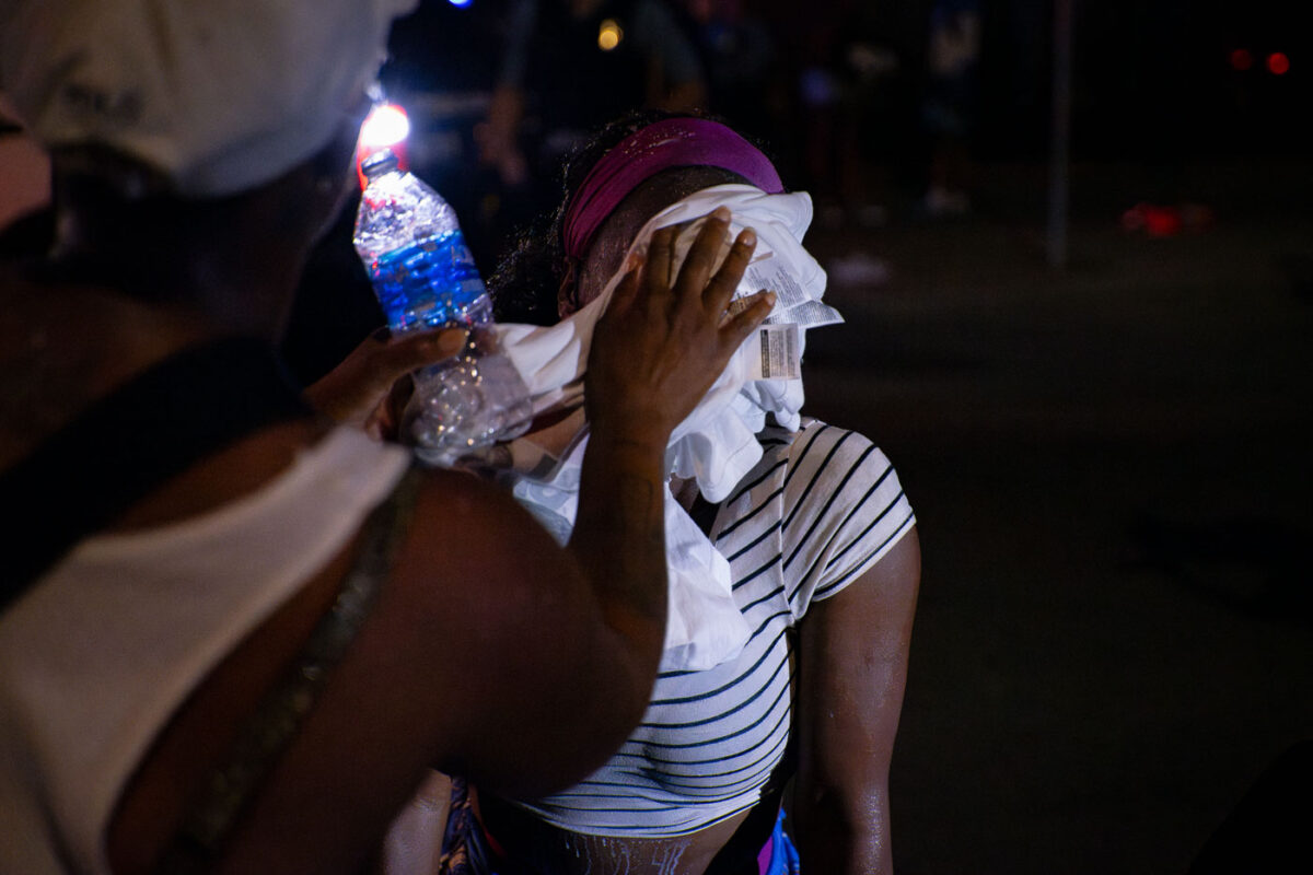 A man helps a woman who had been pepper sprayed by the Minneapolis Police following unrest that broke out over false rumors of a police shooting.
