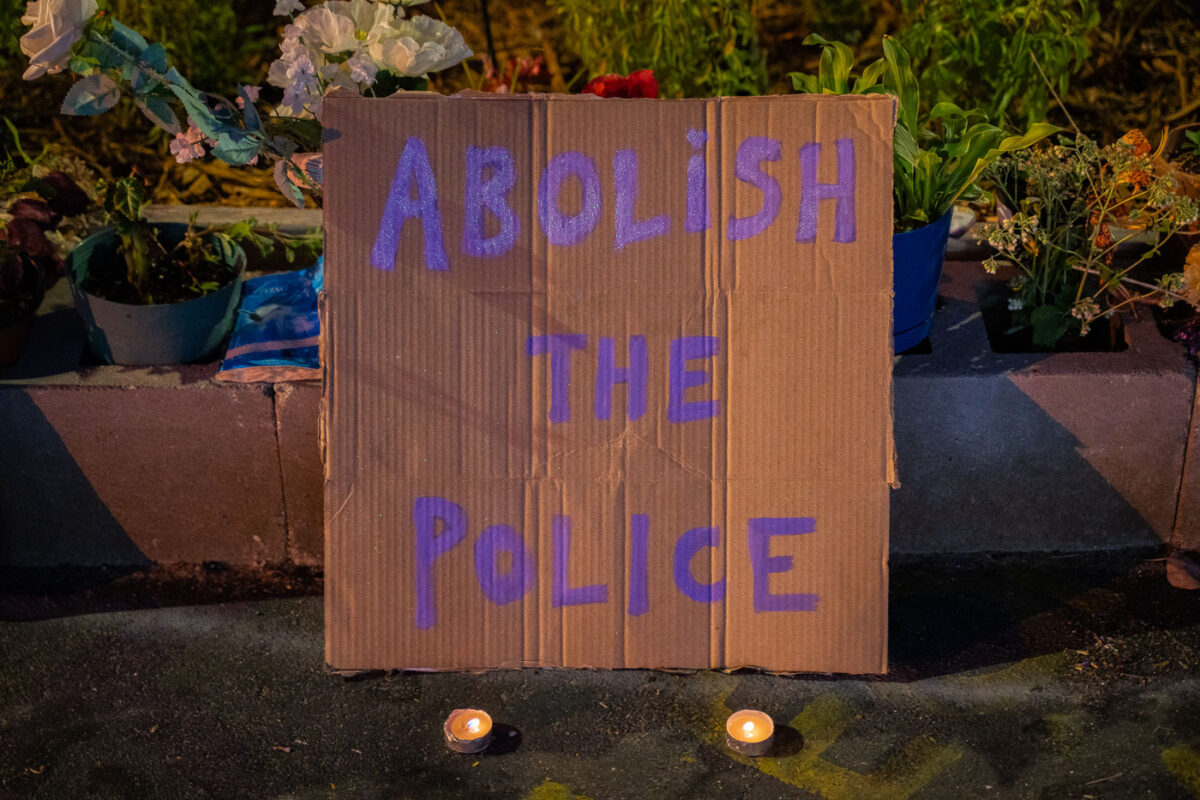 A sign that reads "Abolish the police" laying at the George Floyd Memorial in South Minneapolis.