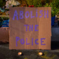 A sign that reads "Abolish the police" laying at the George Floyd Memorial in South Minneapolis.