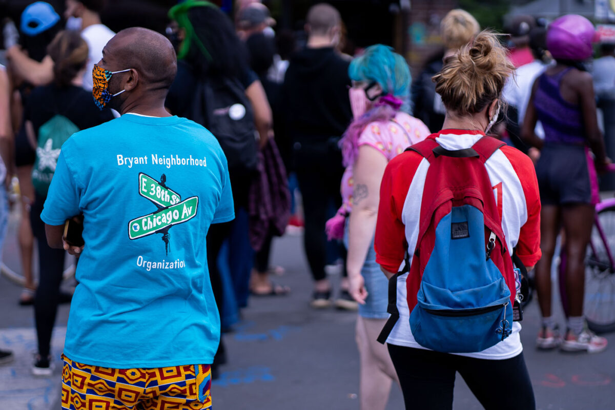 Man wearing a  "Bryant Neighborhood Organization" shirt at George Floyd Square.