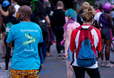 Man wearing a  "Bryant Neighborhood Organization" shirt at George Floyd Square.