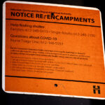 Notice about encampments and COVID-19 posted on the Midtown Greenway in Minneapolis seen on August 10, 2020.