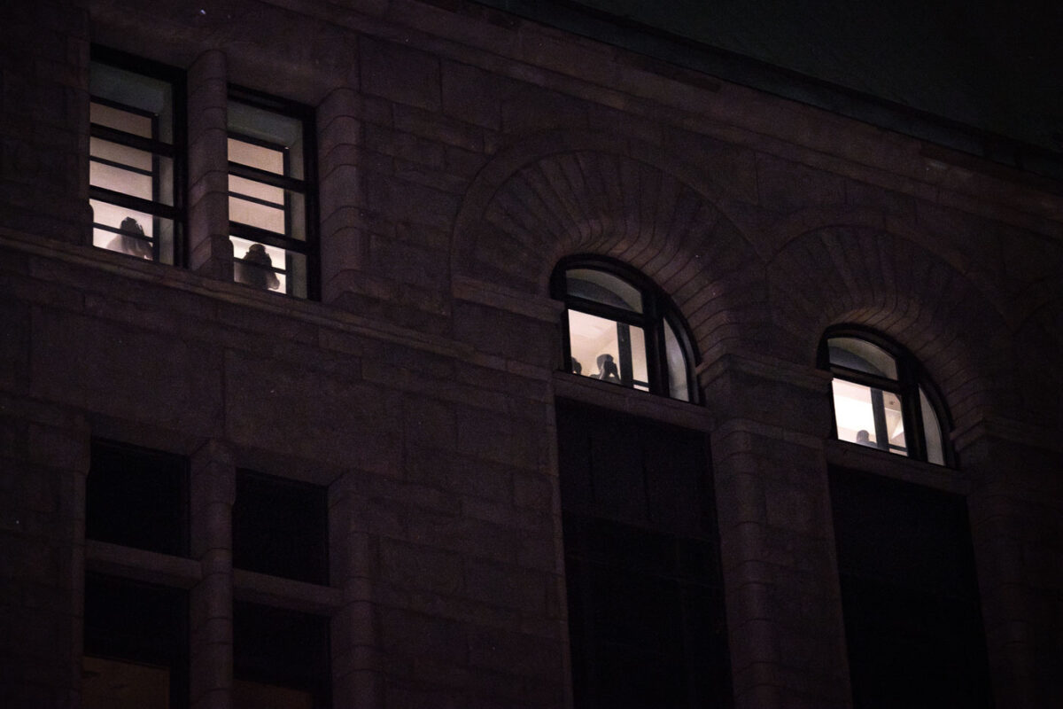 Inmates inside the City Hall Jail look down on protesters outside who are playing music and asking for their release.