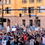 Protesters with signs march through downtown Minneapolis in solidarity with Jacob Blake after he was shot by Kenosha police.