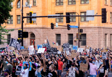 Protesters with signs march through downtown Minneapolis in solidarity with Jacob Blake after he was shot by Kenosha police.