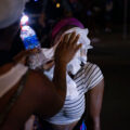 A man helps a woman who had been pepper sprayed by the Minneapolis Police following unrest that broke out over false rumors of a police shooting.