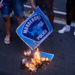 Protesters burn protest signs after a march the evening after Jacob Blake was shot by the Kenosha Police in Wisconsin.