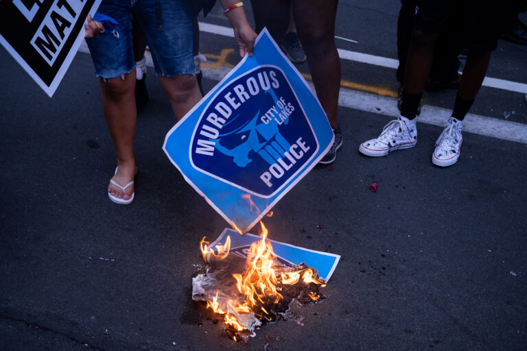Protesters burn signs in Downtown Minneapolis 3 Protesters burn protest signs after a march the evening after Jacob Blake was shot by the Kenosha Police in Wisconsin.