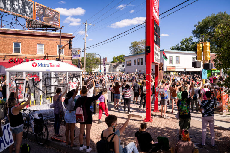 Protesters raise fists at George Floyd Square protest 3 Protesters hold up their first at George Floyd Square in a rally the same day President Trump was in town.