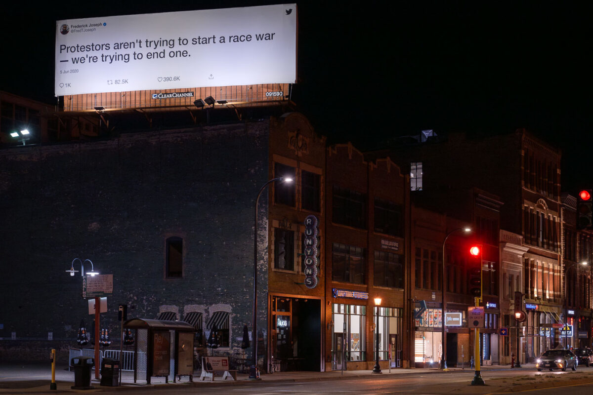 Twitter billboard in downtown Minneapolis displaying a tweet reading "Protesters aren't trying to start a race war - we're trying to end one.".