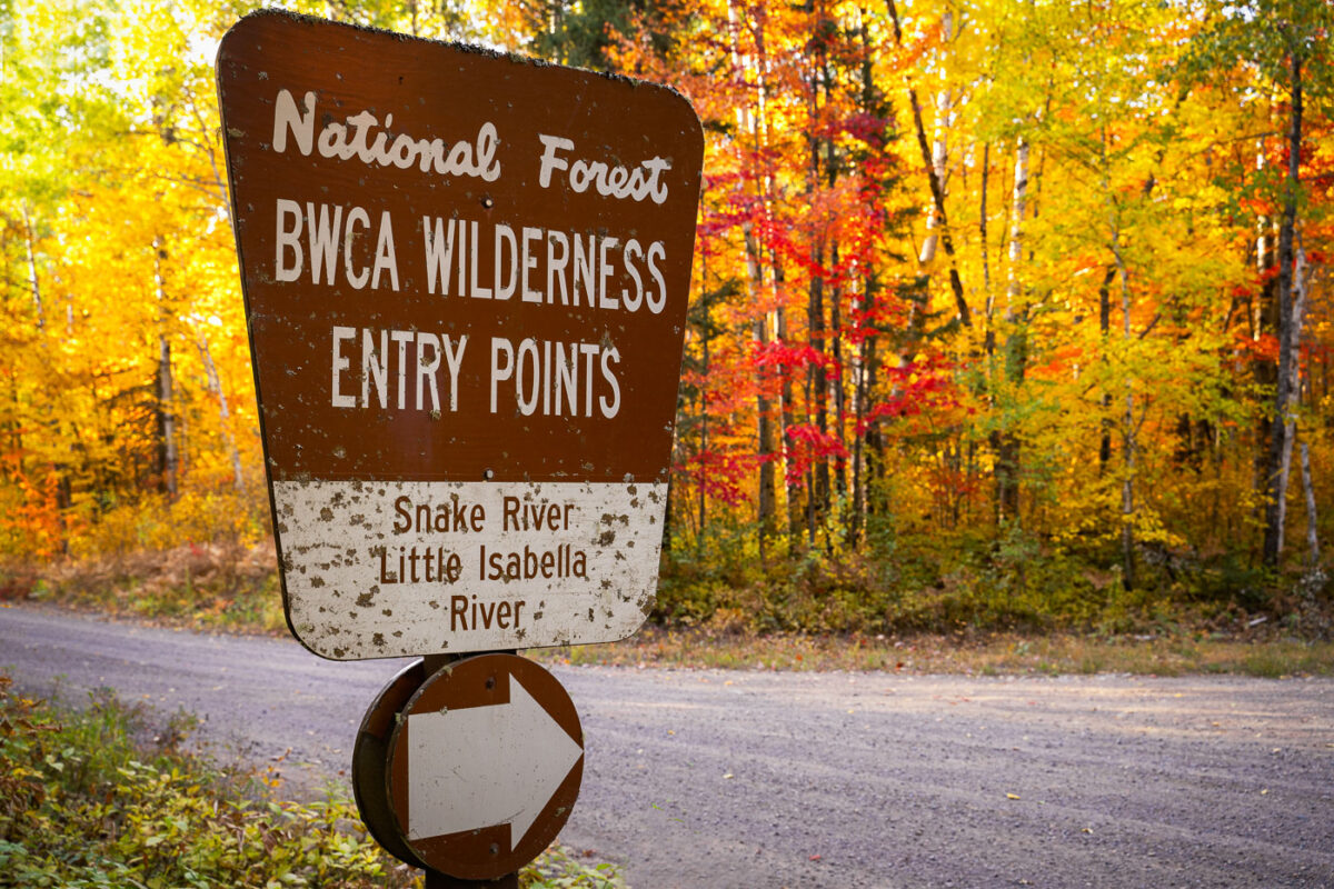 A sign pointing to the BWCA Wilderness Entry Points of Snake River and Little Isabella River. BWCA is located in Northern Minnesota in the Superior National Forest.