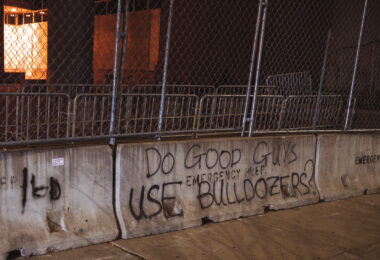 Do Good Guys Use Bulldozers? written on a concrete barricade outside the jail in downtown Minneapolis.