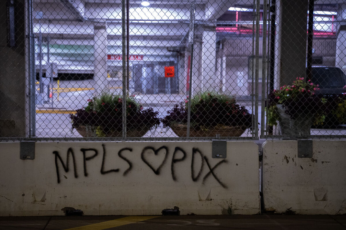 "MPLS Loves PDX" written on concrete barriers across from the Hennepin County jail.