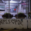 "MPLS Loves PDX" written on concrete barriers across from the Hennepin County jail.