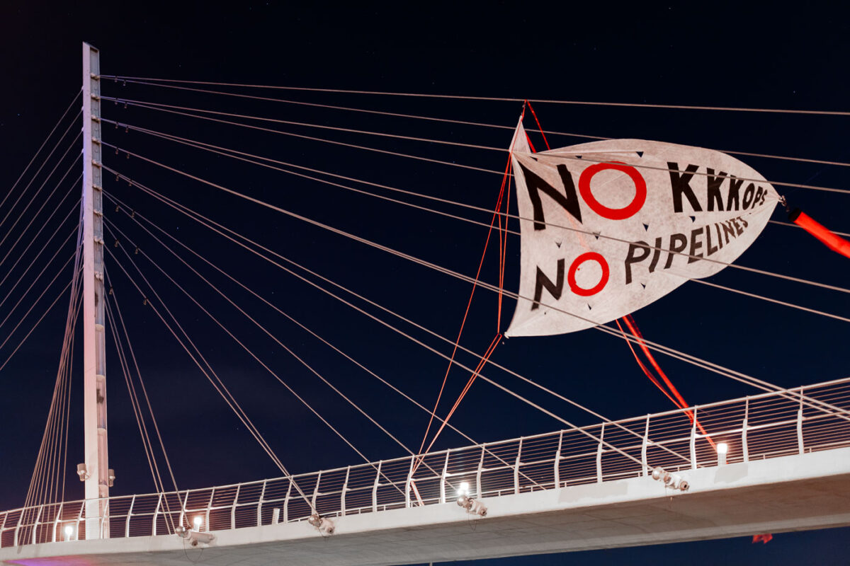 A banner that reads "NO KKKOPS NO PIPELINES" hung over the Martin Olav Sabo Bridge in Minneapolis.