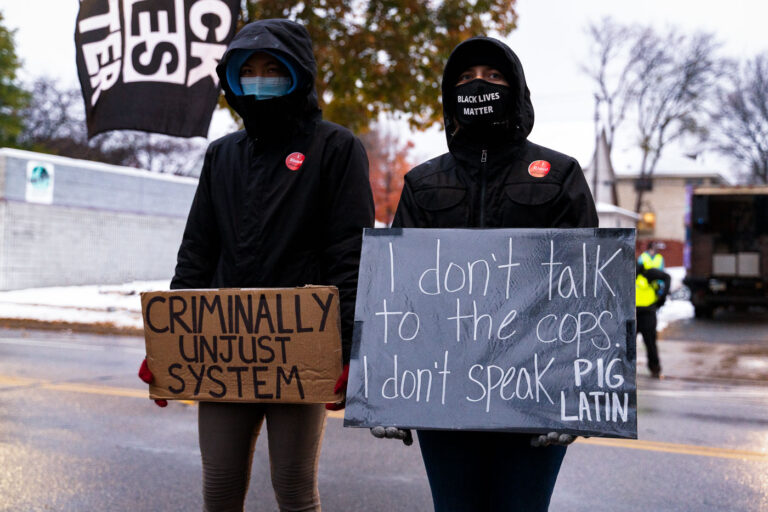 Protesters hold signs at Minneapolis police station 2 Protesters participate in the 25th annual National Day of Protest to Stop Police Brutality, Repression and the Criminalization of a Generation outside the Minneapolis Police fourth precinct.