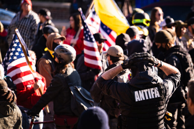 Protesters clash with Proud Boys 4 A man with an ANTIFA patch on the back of his vest at a Stop The Steal rally with Proud Boys.