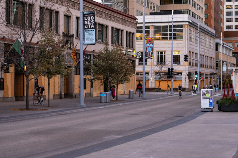 Nicollet Mall boards and bikers 2 Bikers bike past boarded up buildings on Nicollet Mall in Downtown Minneapolis.