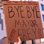 Protester outside Minneapolis Mayor Jacob Frey’s home holds up a sign that reads “Your time is up! Bye, Bye Mayor Frey. Evicted”. Protesters demanding the mayor do something about homelessness in the city.