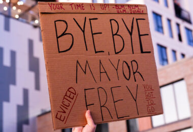 Protester outside Minneapolis Mayor Jacob Frey’s home holds up a sign that reads “Your time is up! Bye, Bye Mayor Frey. Evicted”. Protesters demanding the mayor do something about homelessness in the city.