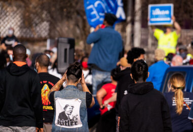 Protester with a large Hitler/Trump patch on her back following a march through Minneapolis after Biden was announced winner of the Presidential election.