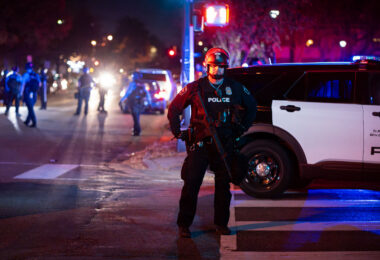 Minneapolis Police officer stands in the street near Bryant Square Park where arrests were made following an election night march through Uptown.