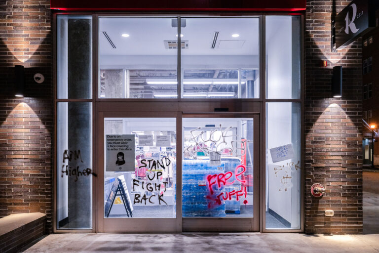 Uptown Minneapolis Target Graffiti: Stand Up Fight Back, Free Stuff 1 Graffiti reading "Stand Up Fight Back" and "Free Stuff!" marks the windows of a Target store in Uptown Minneapolis. This graffiti emerged following a march down Lake Street on election night, reflecting the intense social and political climate in the city. The messages directly relate to the protests and calls for social change that characterized Minneapolis during this period. The defacement of a prominent retail establishment like Target underscores its role as a symbol in broader discussions of economic justice and community grievances.