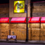 Graffiti on Tires Plus boards that read “Stop Line 3” “No More Prez” “Riots 2020”