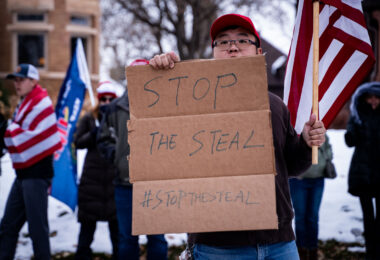 A protester holds up a sign that reads “Stop The Steal” outside the Minnesota Governor’s mansion in St. Paul, Minnesota on November 14, 2020.