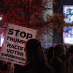 Protester holds up a sign reading “Stop trumps racist voter suppression! Party for Socialism & Liberation”