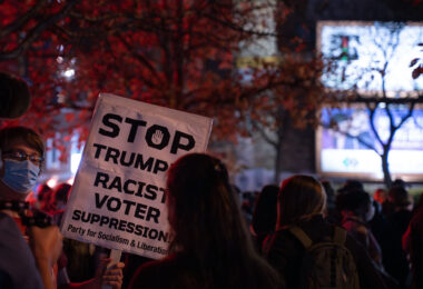 Protester holds up a sign reading “Stop trumps racist voter suppression! Party for Socialism & Liberation”