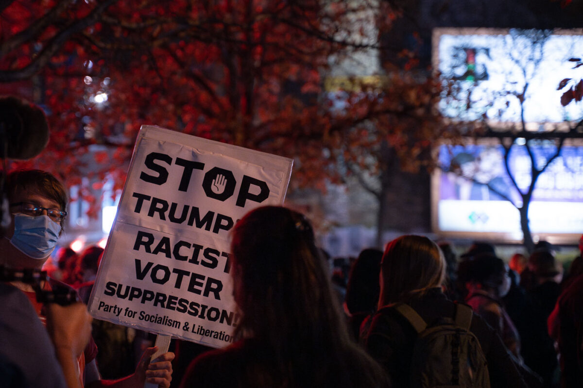 Protester holds up a sign reading “Stop trumps racist voter suppression! Party for Socialism & Liberation”