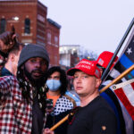 Two men wearing "Make America Great Again" hats disrupt a housing protest outside Minneapolis Mayor Jacob Frey’s home.