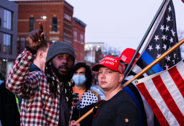 Two men wearing "Make America Great Again" hats disrupt a housing protest outside Minneapolis Mayor Jacob Frey’s home.