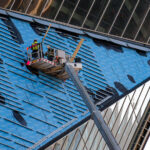 Construction workers work to repair the side of US Bank Stadium in November 2020.
