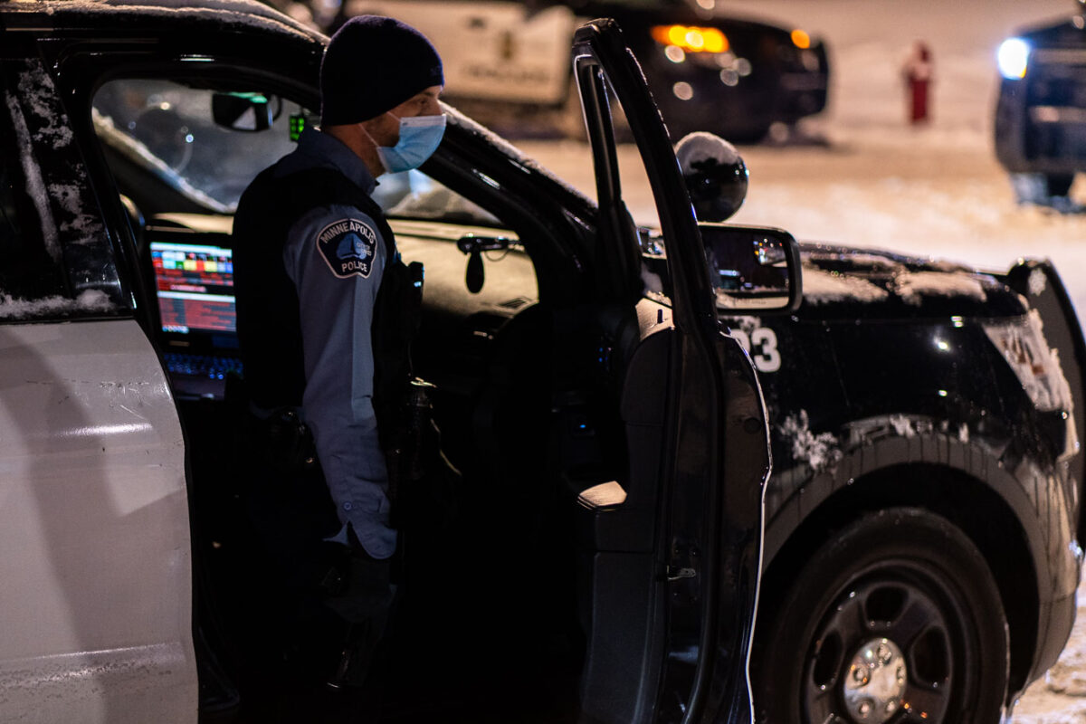 December 27, 2020 - Minneapolis -- Minneapolis Police officer stands near his car with a gun.