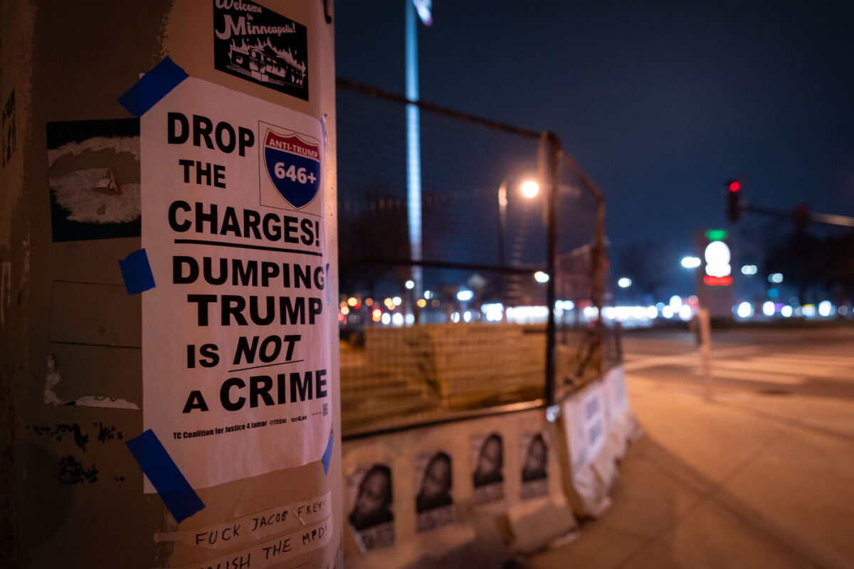 Flyers taped to a pole outside of the Minneapolis Third Precinct police station, which burned after the murder of George Floyd in May 2020. 

Drop the charges refers to the 646 that were criminally charged during the largest mass arrest in Minnesota history. Protesters were arrested after marching onto I-94 in a post election march.