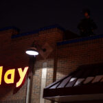Minneapolis Police on the roof of the Holiday gas station as protesters gather outside where Minneapolis police shot and killed Dolal Idd.