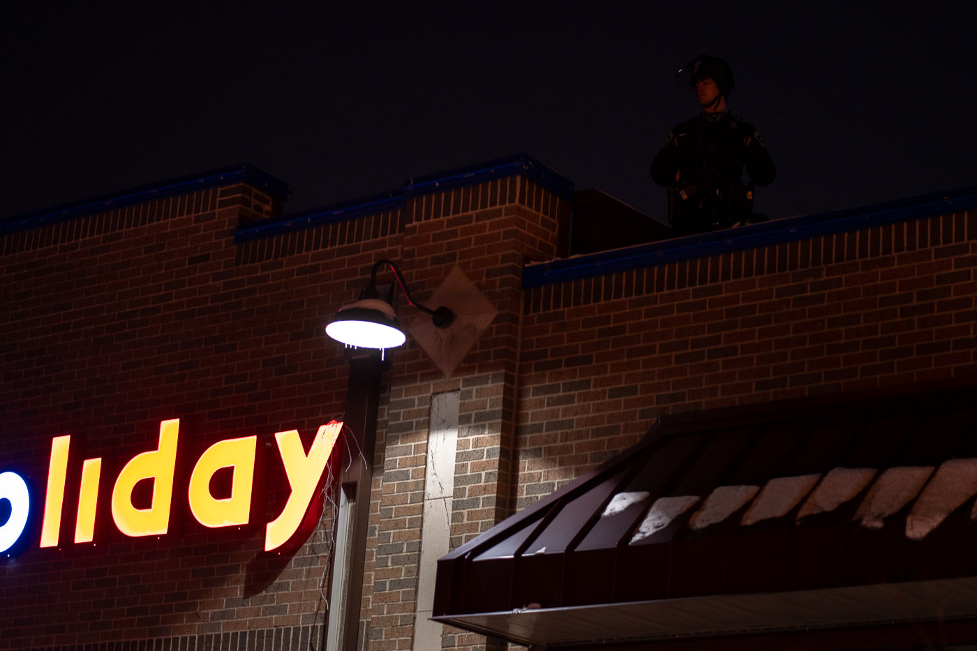 Minneapolis police on roof of Holiday Gas