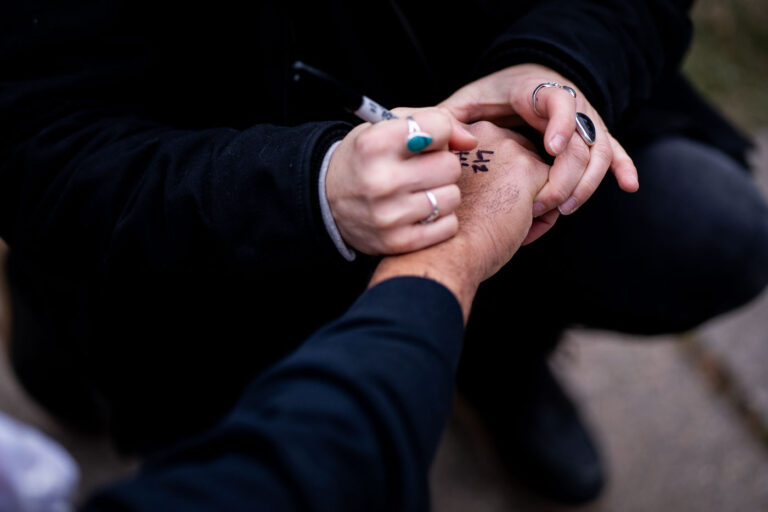 Jail support number written on a protester 4 A Stop The Steal counter protester gets the National Lawyer's Guild Number written on their hand in the event of arrest.