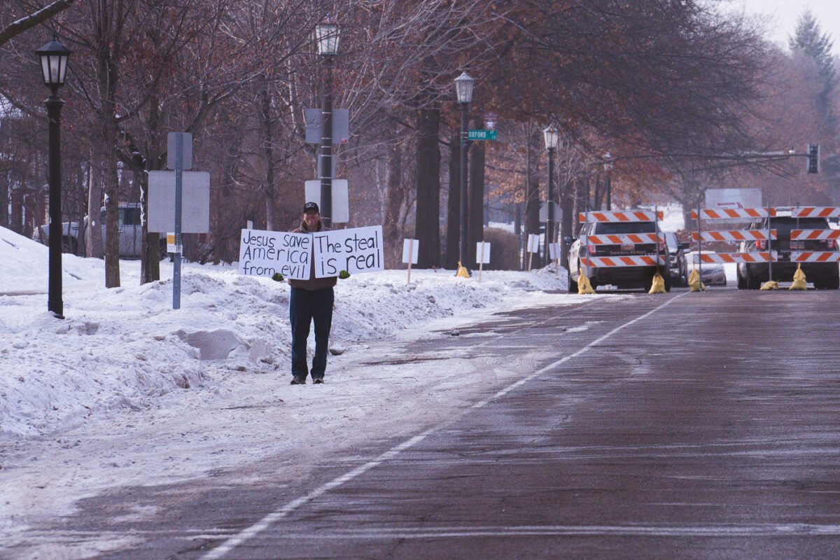 A lone protester holds up a sign reading "Jesus save America from evil. The steal is real" outside the Minnesota Governor's Mansion.