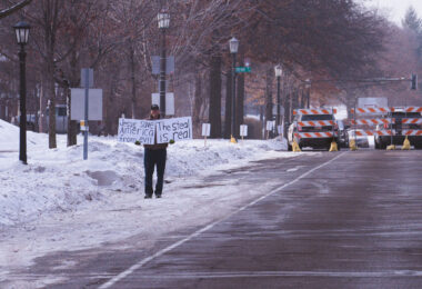 A lone protester holds up a sign reading "Jesus save America from evil. The steal is real" outside the Minnesota Governor's Mansion.