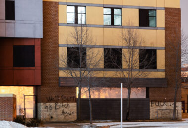 Graffiti on the Minneapolis Police third precinct that reads "We'll burn this bitch again" and "Fuck 12". The precinct has been vacant since it was abandoned by the Minneapolis Police and burned by protesters on May 28th, 2020.