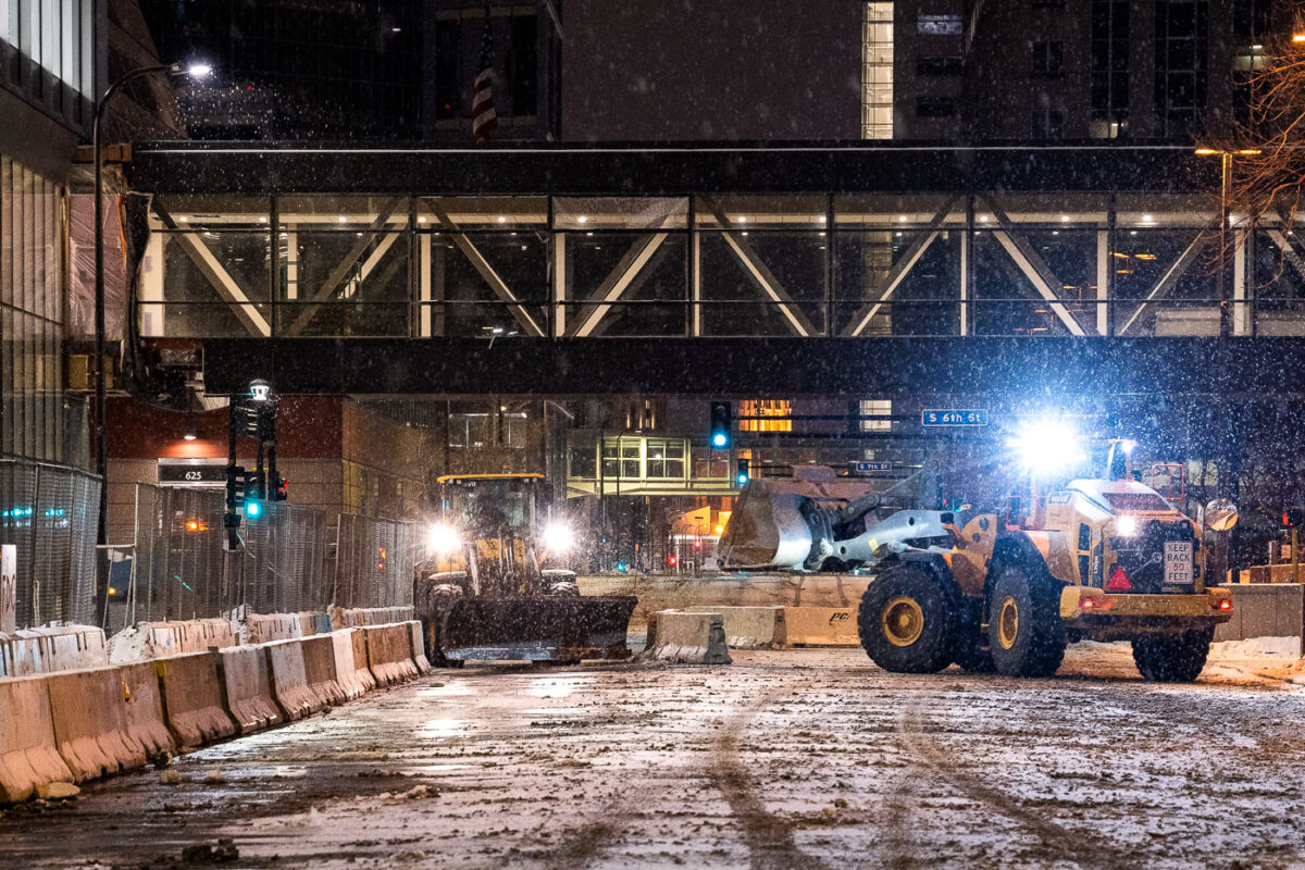 Public Works vehicles work through the night to put jersey barriers in place around government buildings across from the Hennepin County Government Center where Derek Chauvin trial begins in 19 days.