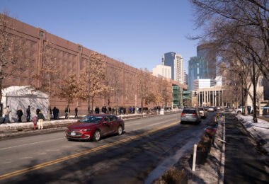 People stand in line for their turn to get the COVID-19 vaccine at the Minneapolis Convention Center.