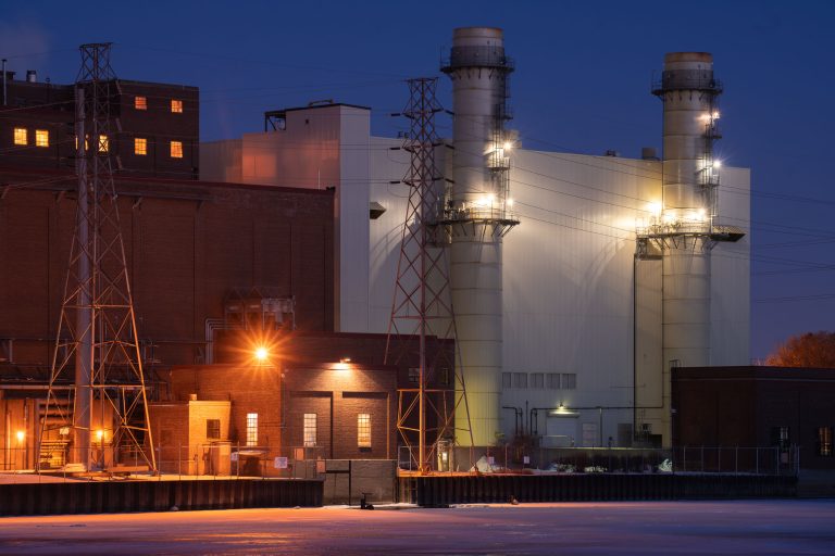 Riverside Generating Station, Minneapolis 1 Riverside Generating Station power plant with tall exhaust stacks and transmission towers at night in Minneapolis.