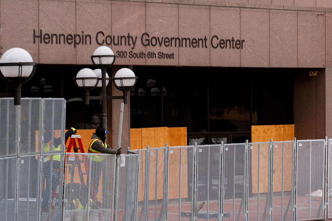 Workers installing security fencing at courthouse for Chauvin trial