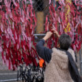 A woman ties ribbons in the shape of a heart to security fencing around the Hennepin County Government Center on the day opening statements began in the Derek Chauvin murder trial. Chauvin is accused of murdering George Floyd on May 25th, 2020.