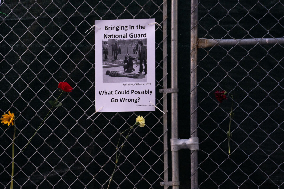 A sign hanging on a fence around the Hennepin County Government Center that reads "Bringing in the National Guard. What could possibily go wrong?".