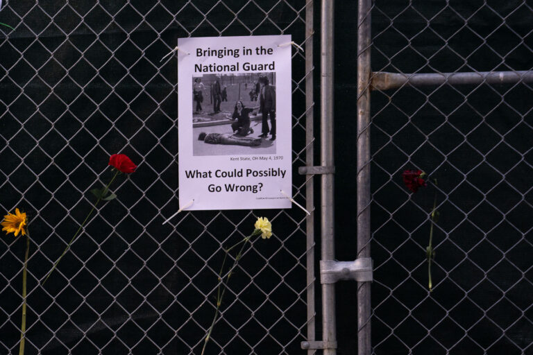 Bringing In the National Guard flyer 3 A sign hanging on a fence around the Hennepin County Government Center that reads "Bringing in the National Guard. What could possibly go wrong?".
